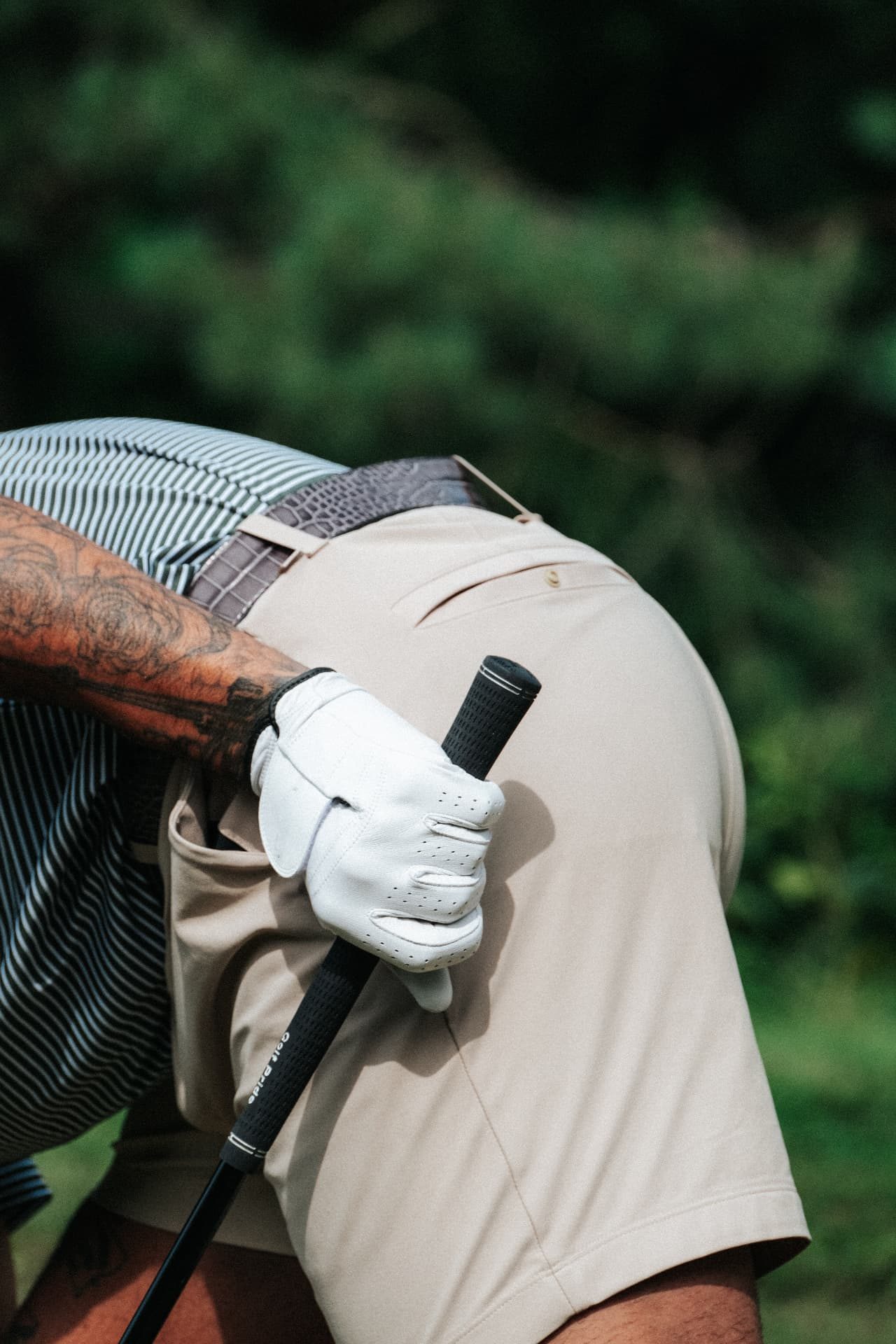 Golfer wearing a Dartee belt with glove tucked at the hip