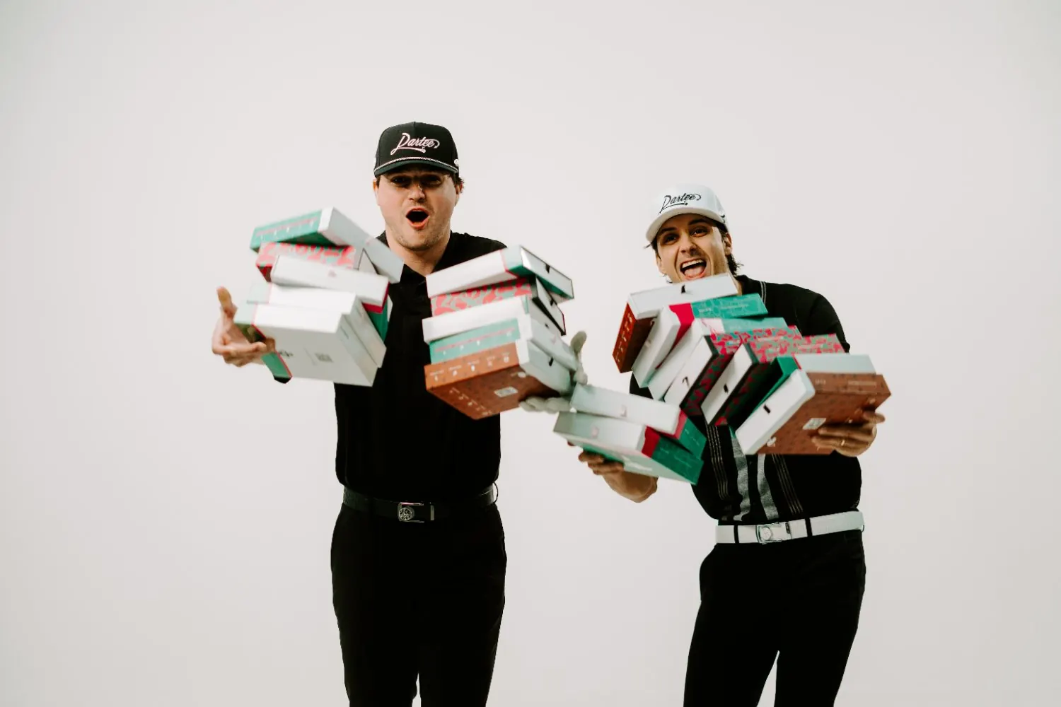The Dartee founders holding stacks of belt boxes