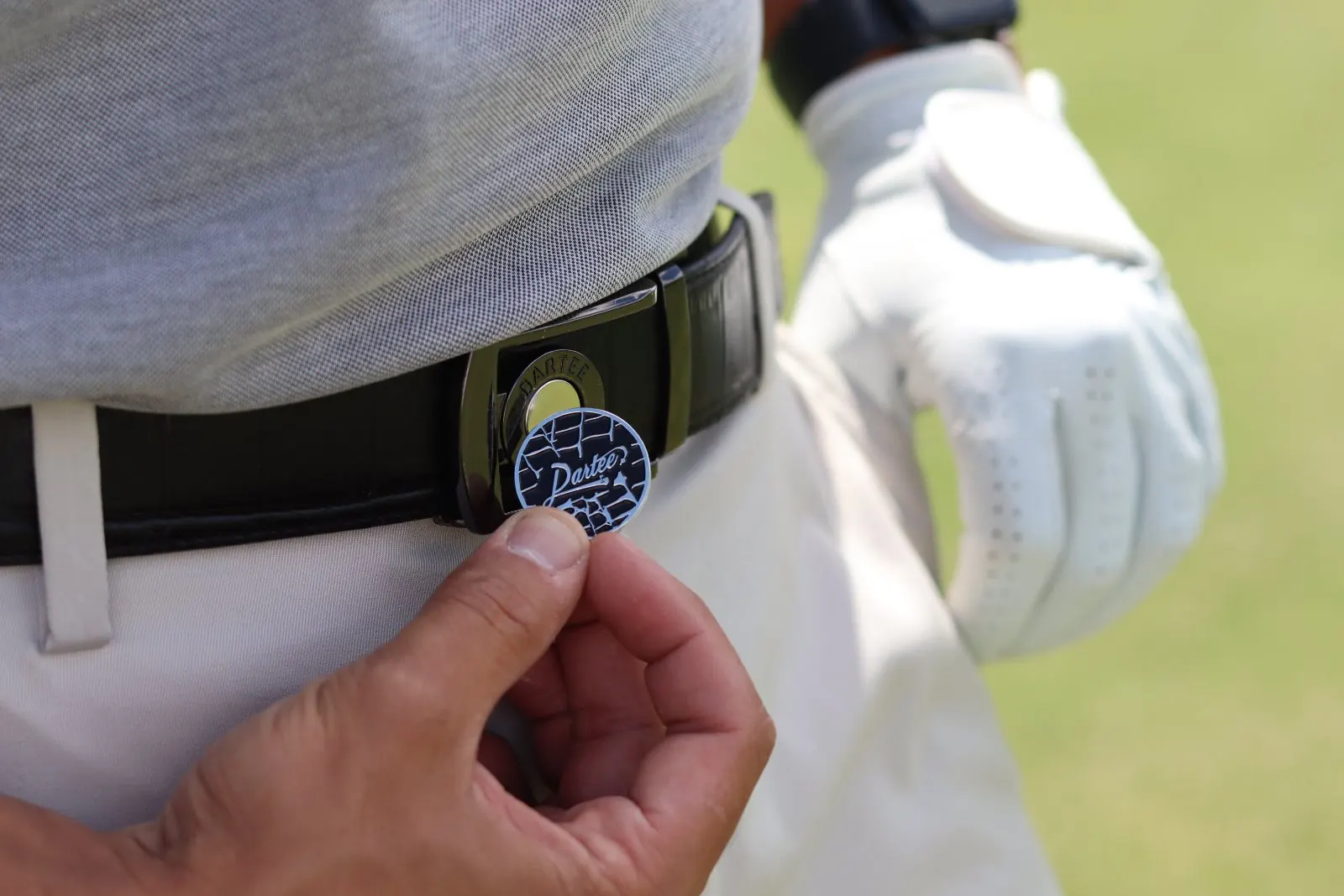 Pulling a custom Dartee ball marker from the buckle